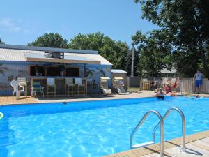 a swimming pool with a house in the background at Little Ted's Cottages in Marblehead