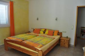 a bedroom with a bed with orange and yellow pillows at Villa Delfin in Sutivan