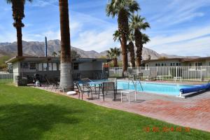 a resort with a pool and palm trees at Stanlunds Inn and Suites in Borrego Springs