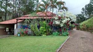 a house with flowers on the side of it at Recanto Caminho das Águas in Caxambu