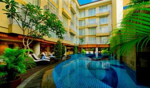 a swimming pool in the middle of a building at Bedrock Hotel Kuta in Kuta