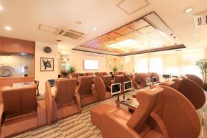 a conference room with brown chairs and tables and a screen at Ueno Station Hostel Oriental Ⅱ(Men Only) in Tokyo