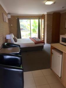 a hotel room with a bed and a window at Huskisson Bayside Resort in Huskisson