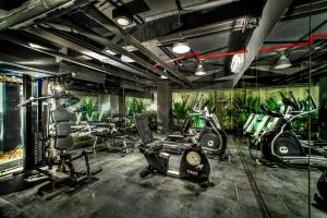 a gym with bikes and exercise equipment in a room at Bedrock Hotel Kuta in Kuta
