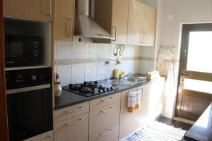 a kitchen with a stove and a sink at Casa das Marias in Horta