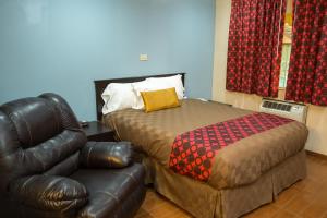 a living room with a couch, chair and a lamp at Townhouse Inn and Suites in Brawley