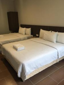 dos camas sentadas una al lado de la otra en una habitación en Hotel Intan Jugra, en Banting