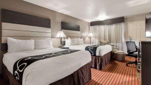 una camera d'albergo con due letti e una scrivania di Best Western Deming Southwest Inn a Deming