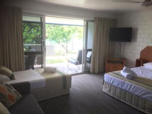 a hotel room with two beds and a balcony at Whitehaven Beachfront Holiday Units in Airlie Beach
