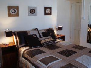 a bedroom with a bed with two lamps and two tables at Wards Hotel in Galway