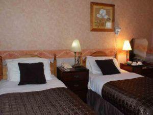 um quarto de hotel com duas camas e duas lâmpadas em Wards Hotel em Galway