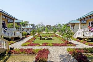 a garden with a bench in the middle of it at Tharu Mahal in Sauraha