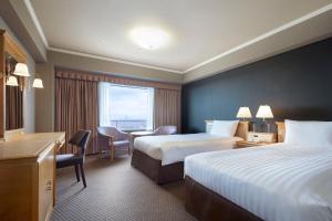 Rúm í herbergi á Hotel Agora Regency Osaka Sakai