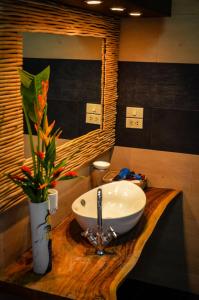 a bathroom with a sink and a vase with flowers at Rice Barn And Rooms in Hang Dong