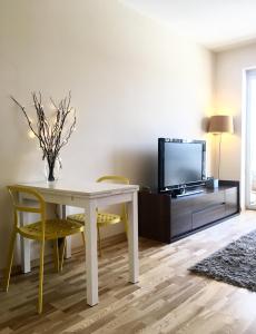 ClickTheFlat Artistic Estate Apartment في وارسو: غرفة معيشة مع طاولة بيضاء وتلفزيون