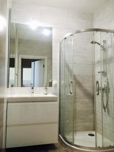 y baño con ducha y lavamanos. en ClickTheFlat Artistic Estate Apartment, en Varsovia