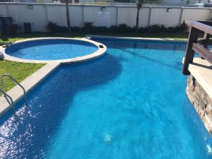 a swimming pool with blue water in a yard at Altara in Boca del Río