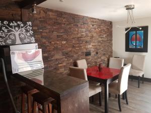 een eetkamer met een tafel en een bakstenen muur bij WindRose 6 in Madrid