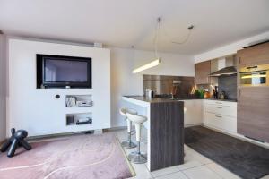 a kitchen with a bar with a tv on the wall at Penthouse bij Leopoldpark in Ostend