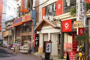 那覇市にある沖縄の宿あじまぁ 牧志の建物の看板が多い街道