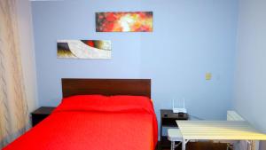 1 dormitorio con cama roja y mesa en Welcome to Santiago - Chile, en Santiago