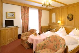 ザールバッハ・ヒンターグレムにあるBoutique-Hotel Bauerのベッド、テーブル、椅子が備わるホテルルームです。