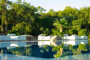 a resort swimming pool with trees in the background at Vallegrande Nature Resort by Geocharme in Cefalù