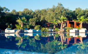 ein Haus mit Palmen und einem Pool in der Unterkunft Vallegrande Nature Resort by Geocharme in Cefalú