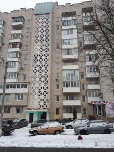 een hoog gebouw met auto's ervoor geparkeerd bij 2-bedroom on Mykolaychuka street in Vinnytsya