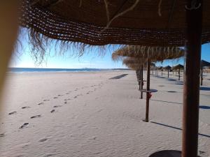 una playa con sombrillas y huellas en la arena en Apartamento Sol e Mar 2, en Monte Gordo 13 fotos más