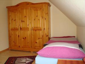 een slaapkamer met een bed en een houten kast bij Ferienwohnung Stauch in Tating