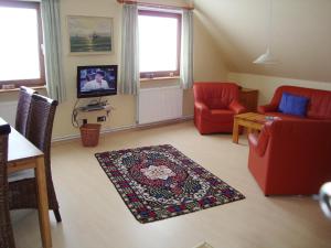 a living room with a red couch and a rug at Ferienwohnung Stauch in Tating