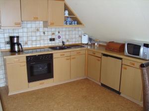 a small kitchen with a sink and a microwave at Ferienwohnung Stauch in Tating