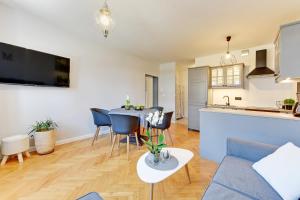 a living room with a blue couch and a table at Motława Apartment - the Best Location in Gdańsk