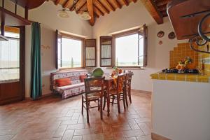 a kitchen and living room with a table and chairs at Podere Tre Cipressi in Campiglia Marittima