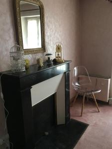 a living room with a fireplace and a mirror at La Maison du Bonheur - Grande maison de vacances classée 4 étoiles in Le Boupère