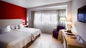 Habitación de hotel con cama y silla en Hotel Europa, en Jaén