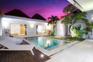 a villa with a swimming pool and a house at Villa Angela in Seminyak