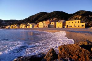 a beach with a group of houses and the ocean at Hotel Liliana in Varigotti