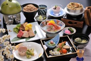 a table with many plates of food on it at Hotel New Kotobuki in Matsumoto