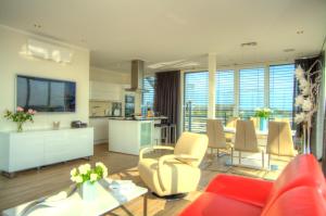 a living room with a red couch and a kitchen at Penthouse Müritzblick in Rechlin