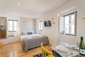 a bedroom with a bed and a table with a dining room at Alfama Loft Studio Loft Apartment w/ River View - by LU Holidays in Lisbon