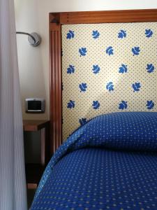 a bedroom with a blue bed with a wall with blue birds at Hotel Il Castellaccio in Piccione