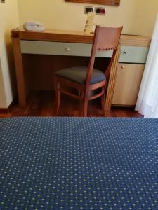 a desk and a chair in a room with a bed at Hotel Il Castellaccio in Piccione