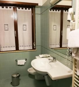 a bathroom with a sink and a toilet and a mirror at Hotel Il Castellaccio in Piccione
