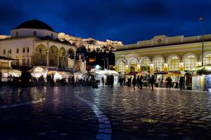 a group of people walking around a street at night at Sweet stone apartment in Imittos in Athens