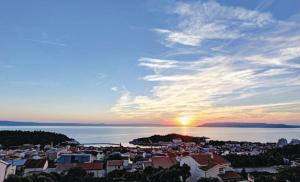 a view of a city with the sun setting over the water at Holiday Home Vrcani in Veliko Brdo