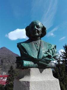 una estatua de una mujer sentada sobre un monumento en Albergo ristorante Gnocchi, en Cortenova