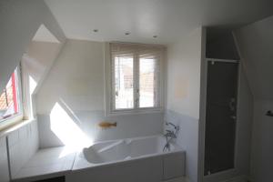 a white bathroom with a tub and a window at Villa Touquettoise et Cape Cod in Le Touquet-Paris-Plage +46 photos