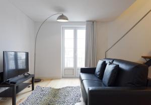 リスボンにあるCity Stays Alegria Apartmentsのリビングルーム(黒いソファ、テレビ付)